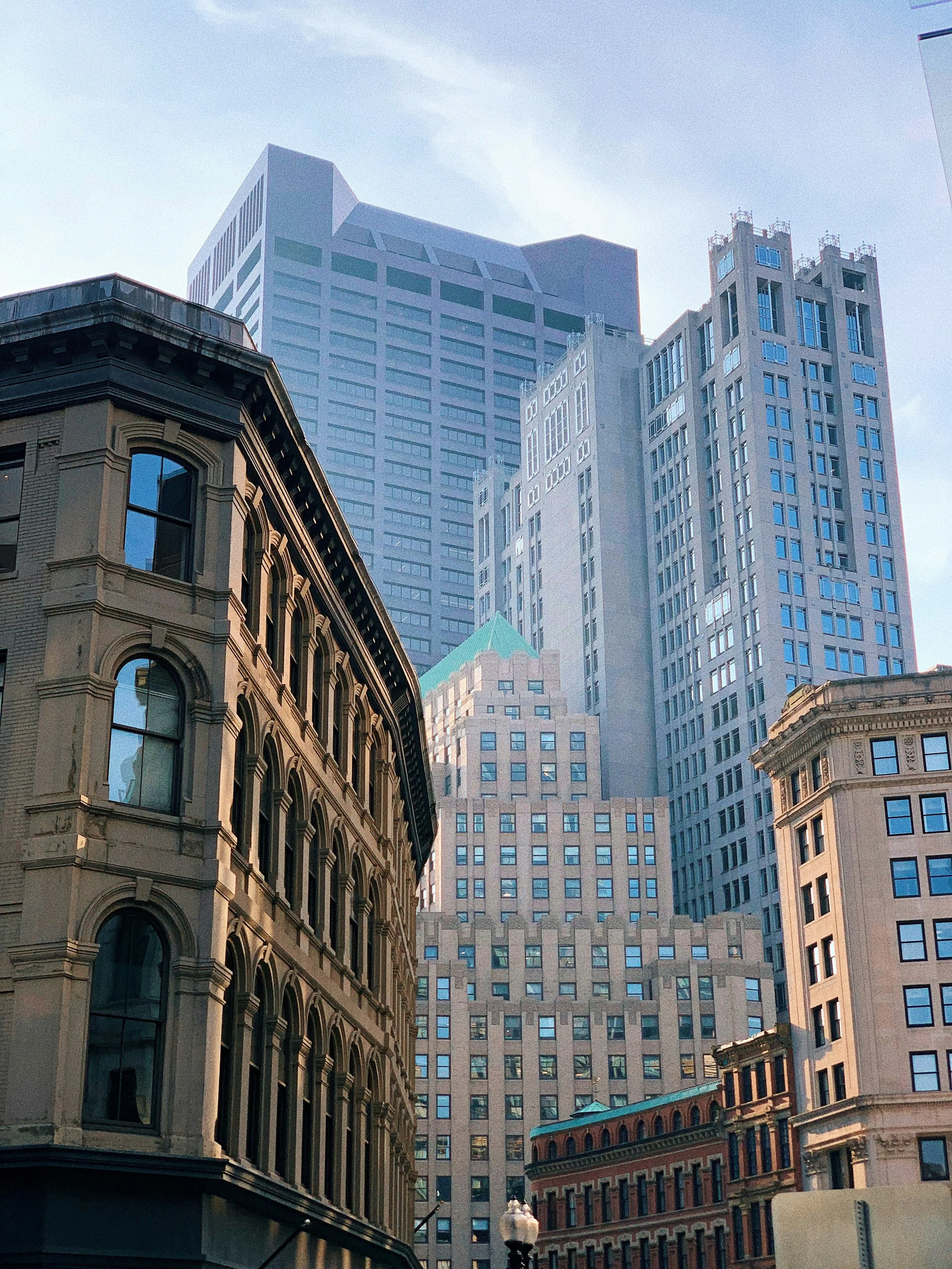 Downtown Boston under a clear sky, featuring ornate architecture on the foreground building.