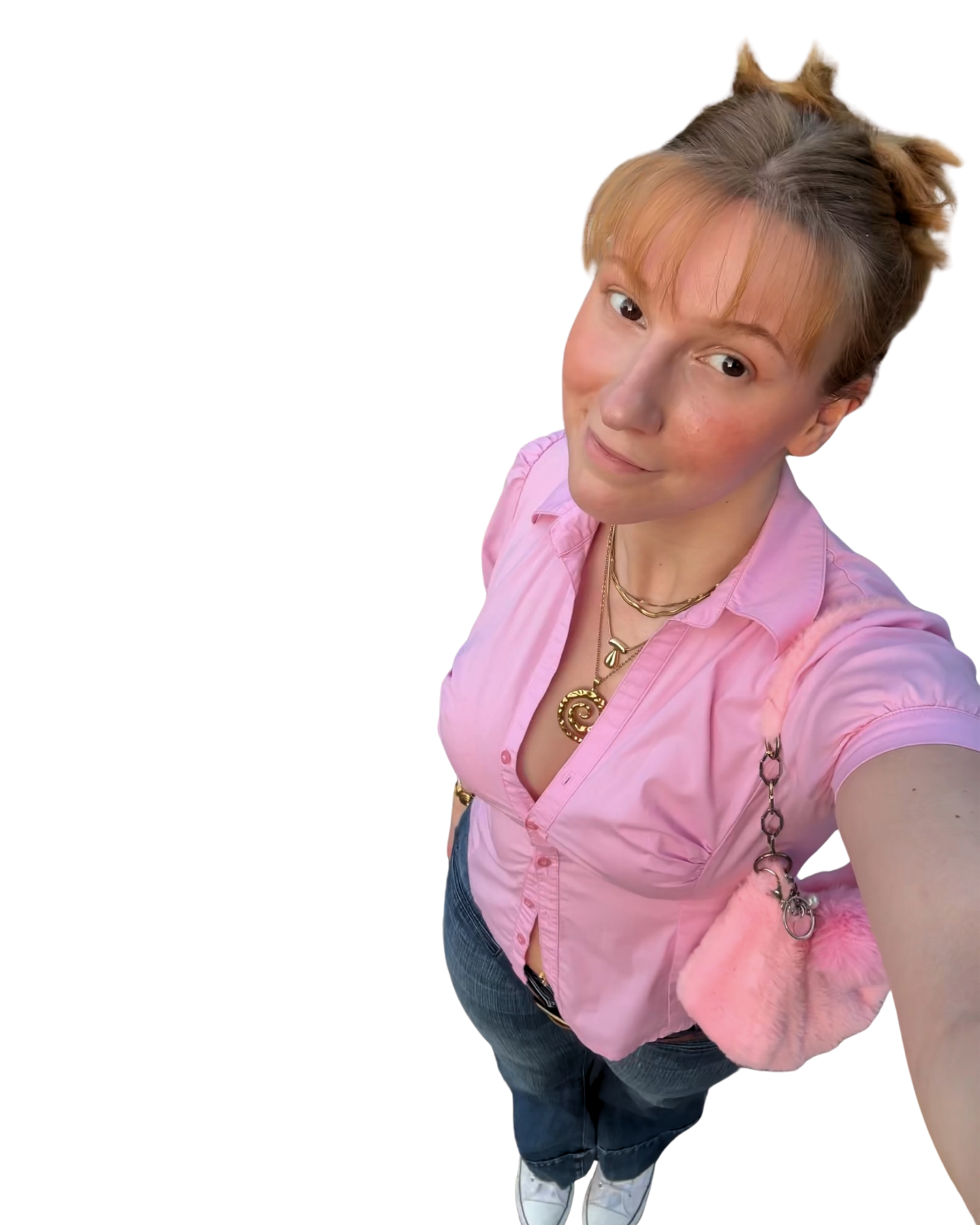 Junge Frau mit orangefarbenem Zopf nimmt Selfie von schräg oben auf und trägt eine pinke Bluse, Jeans, weiße Turnschuhe und goldenen Schmuck.
