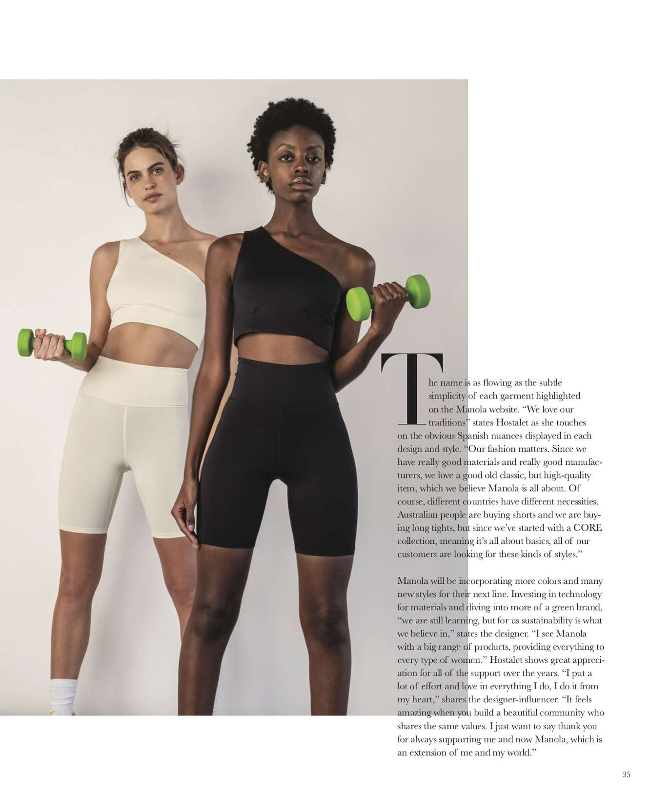 Two women with athletic physiques standing against a plain background, holding green dumbbells. The woman in front has dark skin and curly hair, dressed in a black one-shoulder workout top and matching shorts. The woman behind has light skin and brow