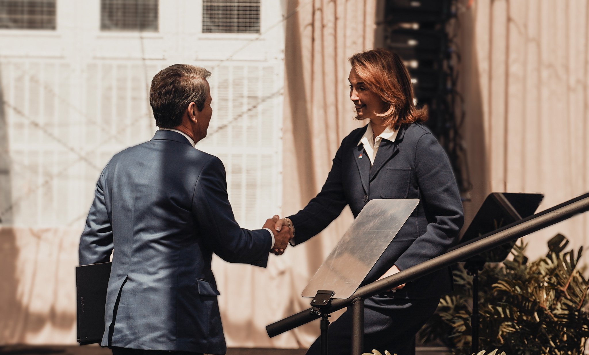 GA Govenor Kemp shaking hands with Chairman, president and chief executive officer of Georgia Power, Kim Greene