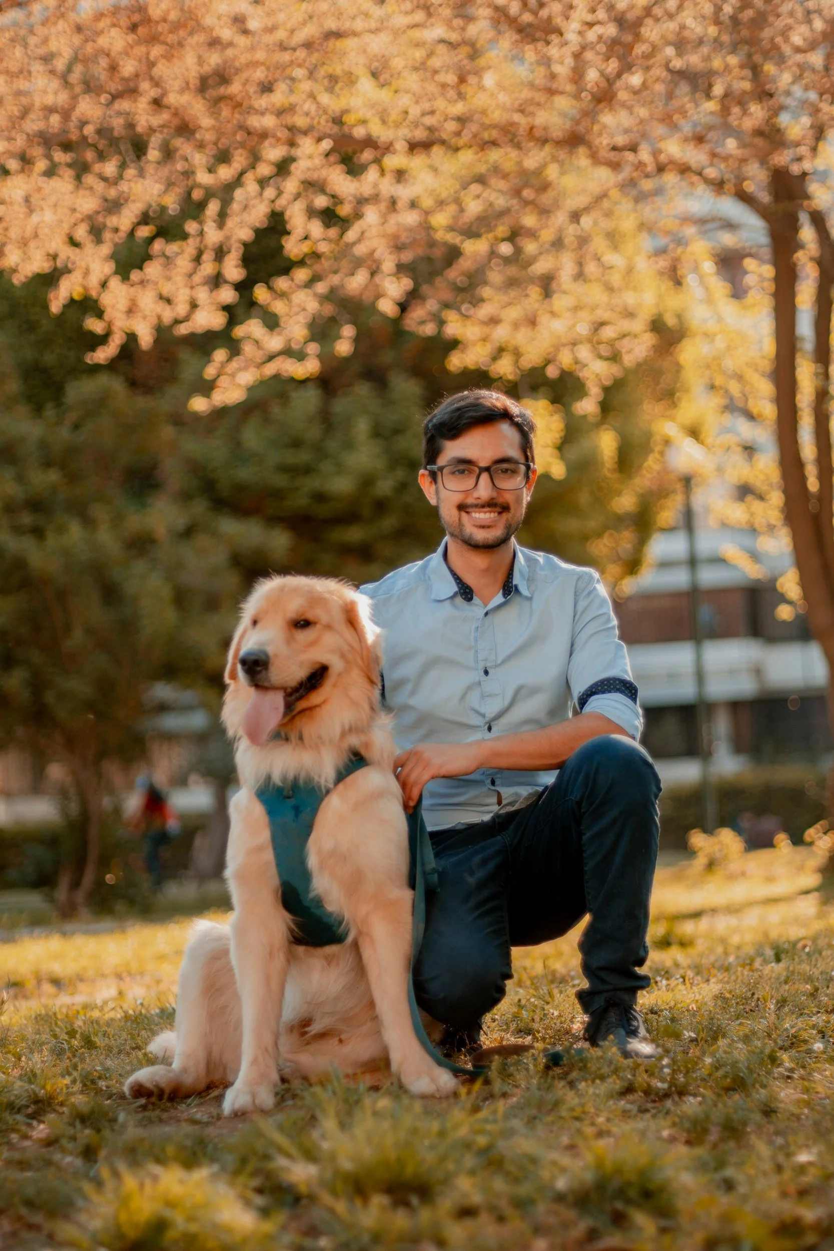 A man spending time outdoors in a vibrant fall landscape with his golden Labrador, showcasing the comforting bond between an individual and their emotional support dog