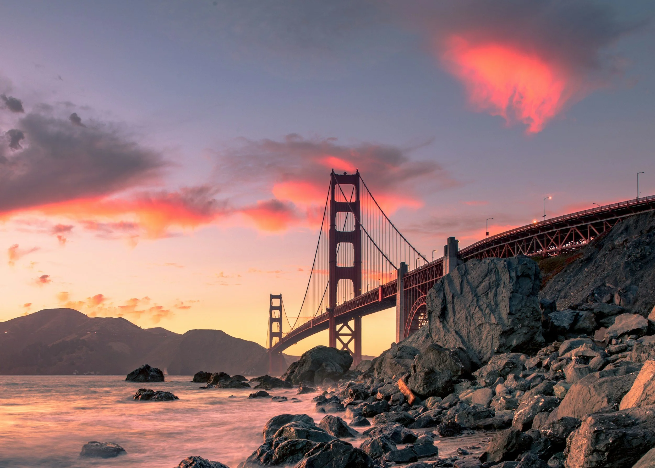 Golden Gate Bridge framed by coastal clouds at sunset in San Francisco California