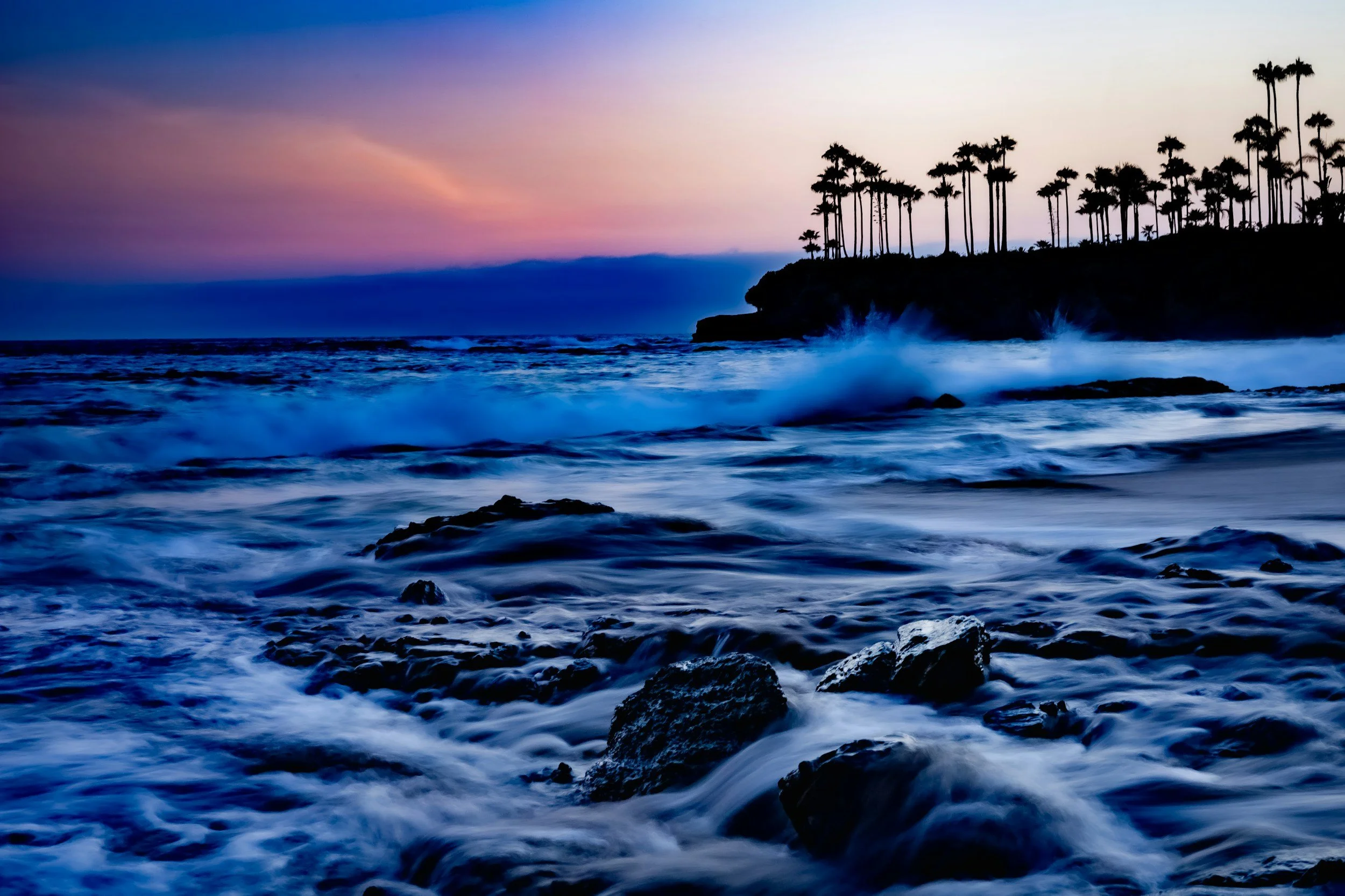 An image of Laguna Beach and nighttime waves calming the shore.