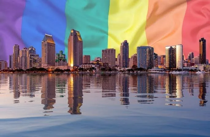 Image depicting San Diego skyline waterfront with rainbow flag in background, showcasing pride and vibrant community.