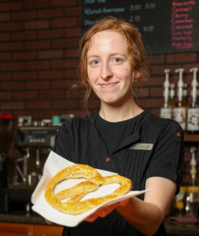 Fresh bavarian pretzel being presented by a Kaffee Klatsch barista.