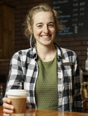 Smiling Kaffee Klatsch team member welcoming customers.