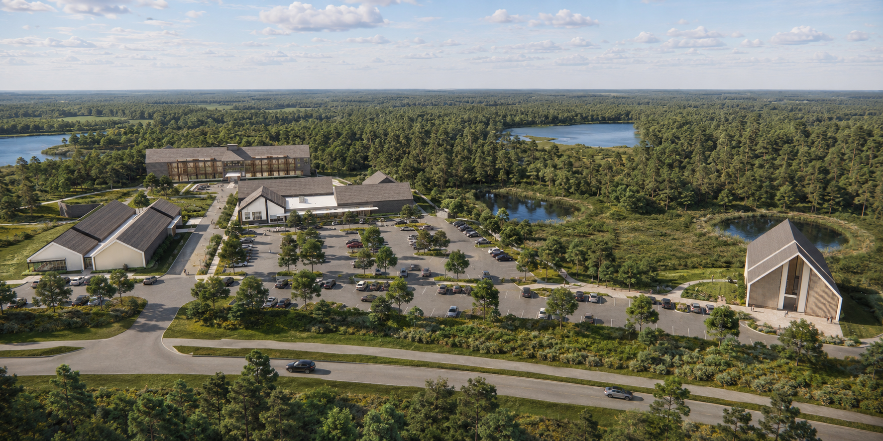 Aerial view of a modern building complex surrounded by a parking lot, green trees, and lakes, with a forest in the background under a partly cloudy sky.
