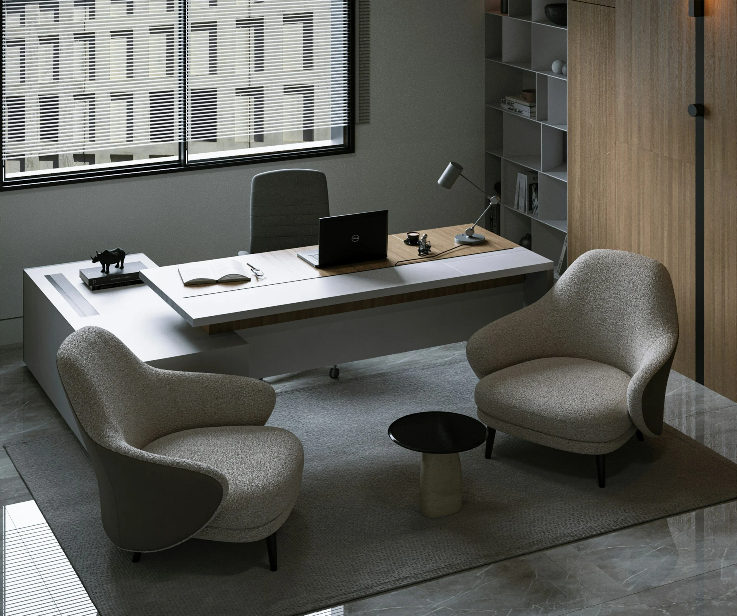 An office with a desk, a gray office chair, a small black side table, and two modern, rounded armchairs. The desk has an open laptop, a desk lamp, an open book, and some small objects. There are gray shelves with books and decorative items behind the desk. A large window with blinds overlooks a modern building outside.