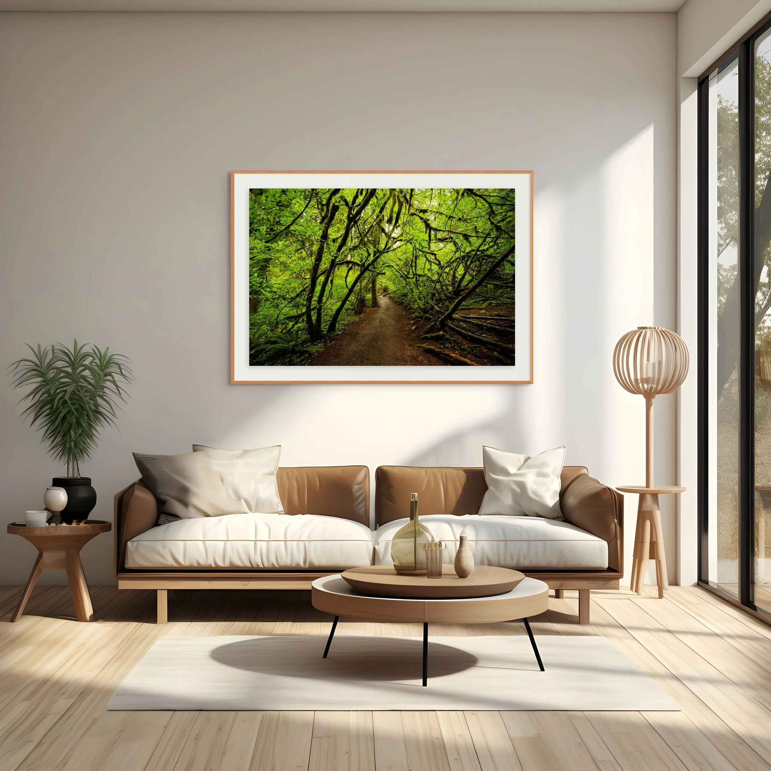 Modern living room with a white sofa, wooden coffee table, potted plant, framed picture of a green forest trail, and a wooden floor.