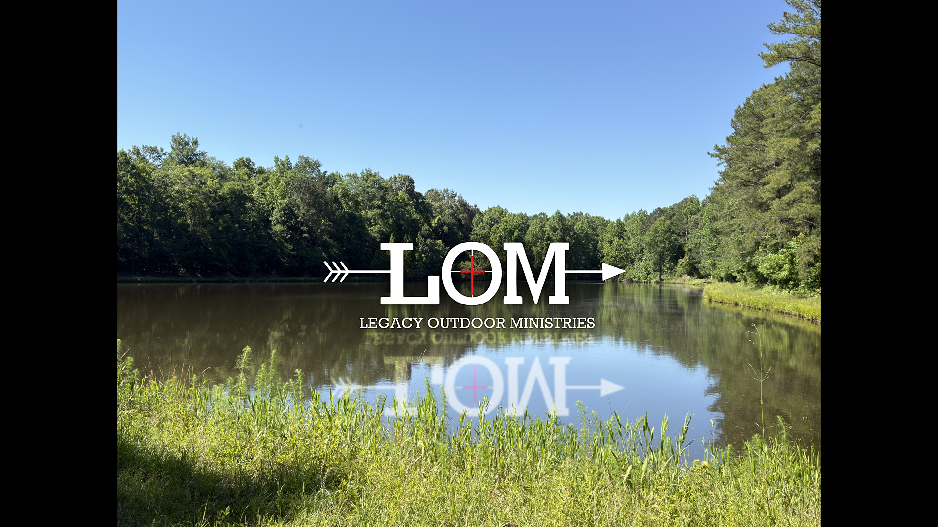 A peaceful outdoor scene featuring a river with tall grass in the foreground, lush green trees on both sides, and a clear blue sky, with a logo for Legacy Outdoor Ministries overlaid.