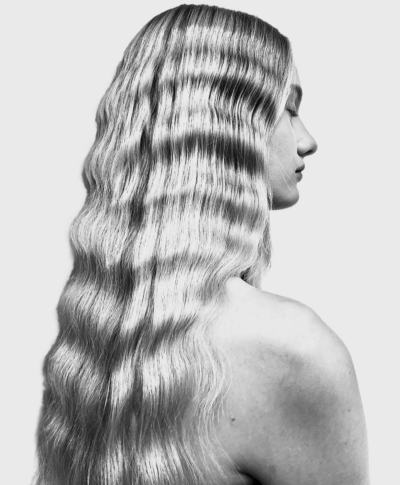 Black and white profile of a woman with long, wavy hair.