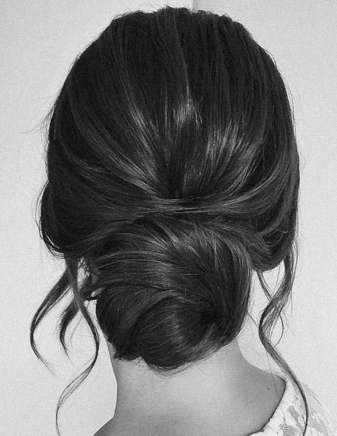 Back view of a woman's dark, wavy hair styled in an elegant updo.
