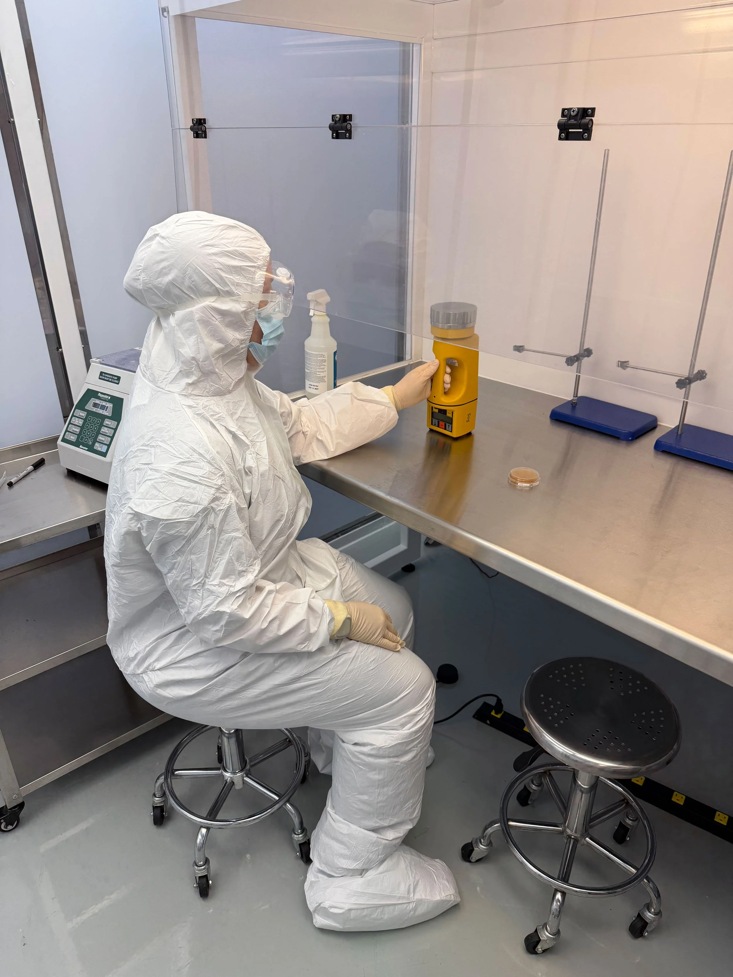 Certified cleanroom technician performing HEPA filter testing at a sterile compounding workbench