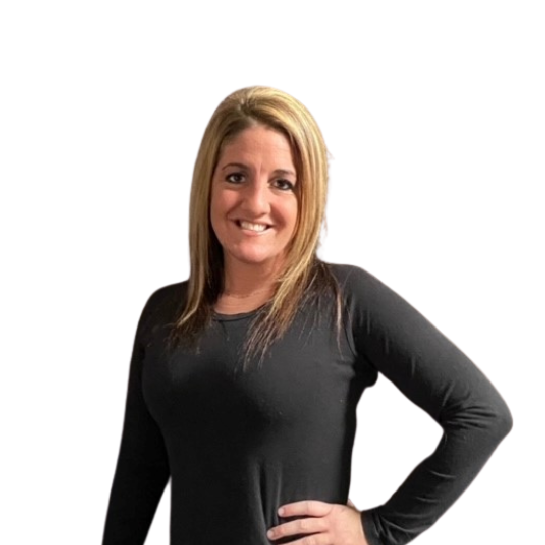 A smiling woman with blonde hair wearing a black long sleeve shirt, standing with her hand on her hip against a white background.