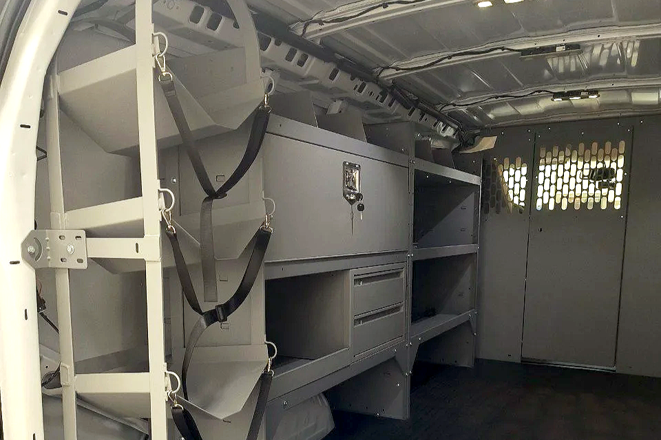 Interior of a vehicle with shelves and storage compartments, likely a police car or service van.