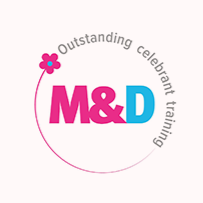 Logo with pink and blue text reading 'M&D' and a pink flower, surrounded by the words 'Outstanding celebrant training' in a circular arrangement.