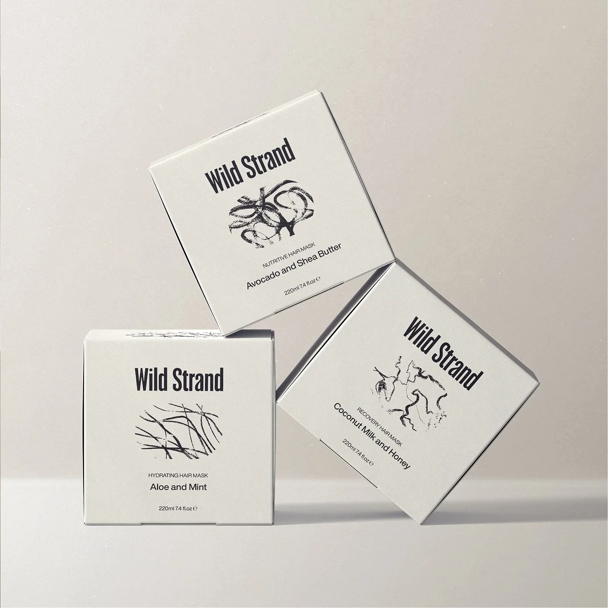 Three white boxes of Wild Strand hair masks, with black text and illustrations, arranged on a white surface and background.