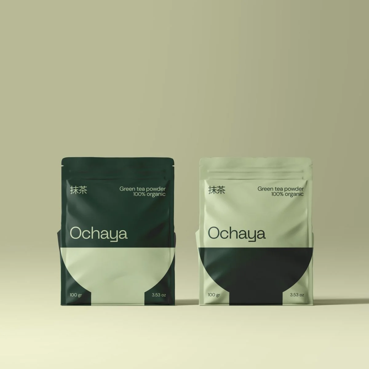 Two pouches of Ochaya green tea powder, one in a dark green package and the other in a light green package, both labeled 100 grams and 3.53 ounces, with minimalist design and black semicircular graphic.
