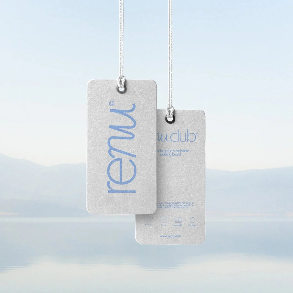 Two clothing tags hanging on white strings, with a faint landscape of mountains and water in the background, promoting Renu, a sustainable clothing brand.