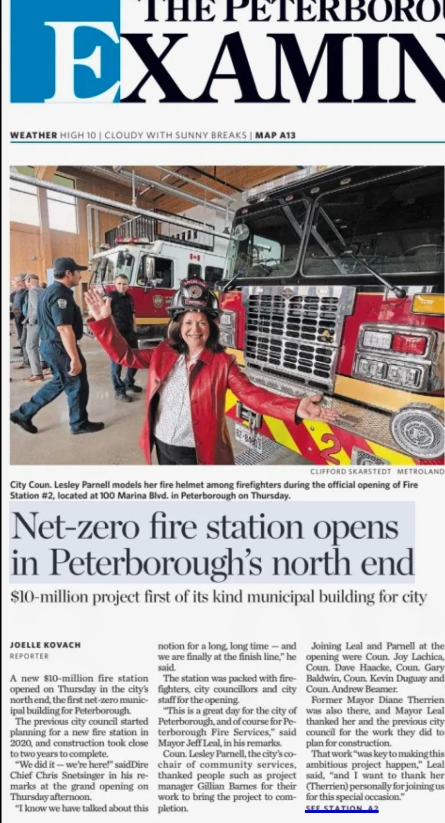 Front page of the Peterborough Examiner newspaper showing a firefighter smiling and waving in front of fire trucks during the opening of a new fire station.