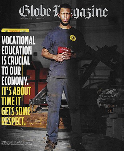 Young man in work clothes holding a red hard hat on the cover of Globe Magazine, with text about vocational education and the economy.