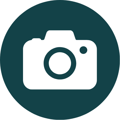 Icon of a camera on a dark teal circular background