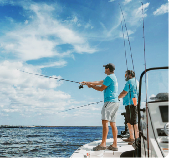 Two men fishing off a boat on a clear, sunny day with a partly cloudy sky