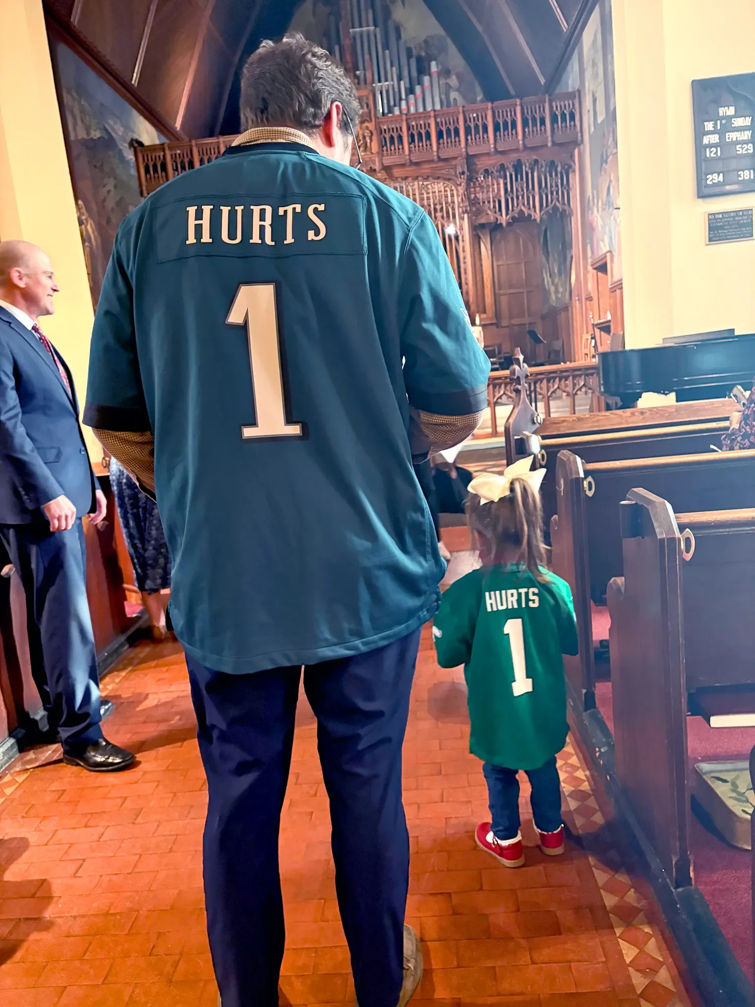 Father and daughter wearing Eagles jerseys after baptism service at St. Thomas’ Church Whitemarsh.