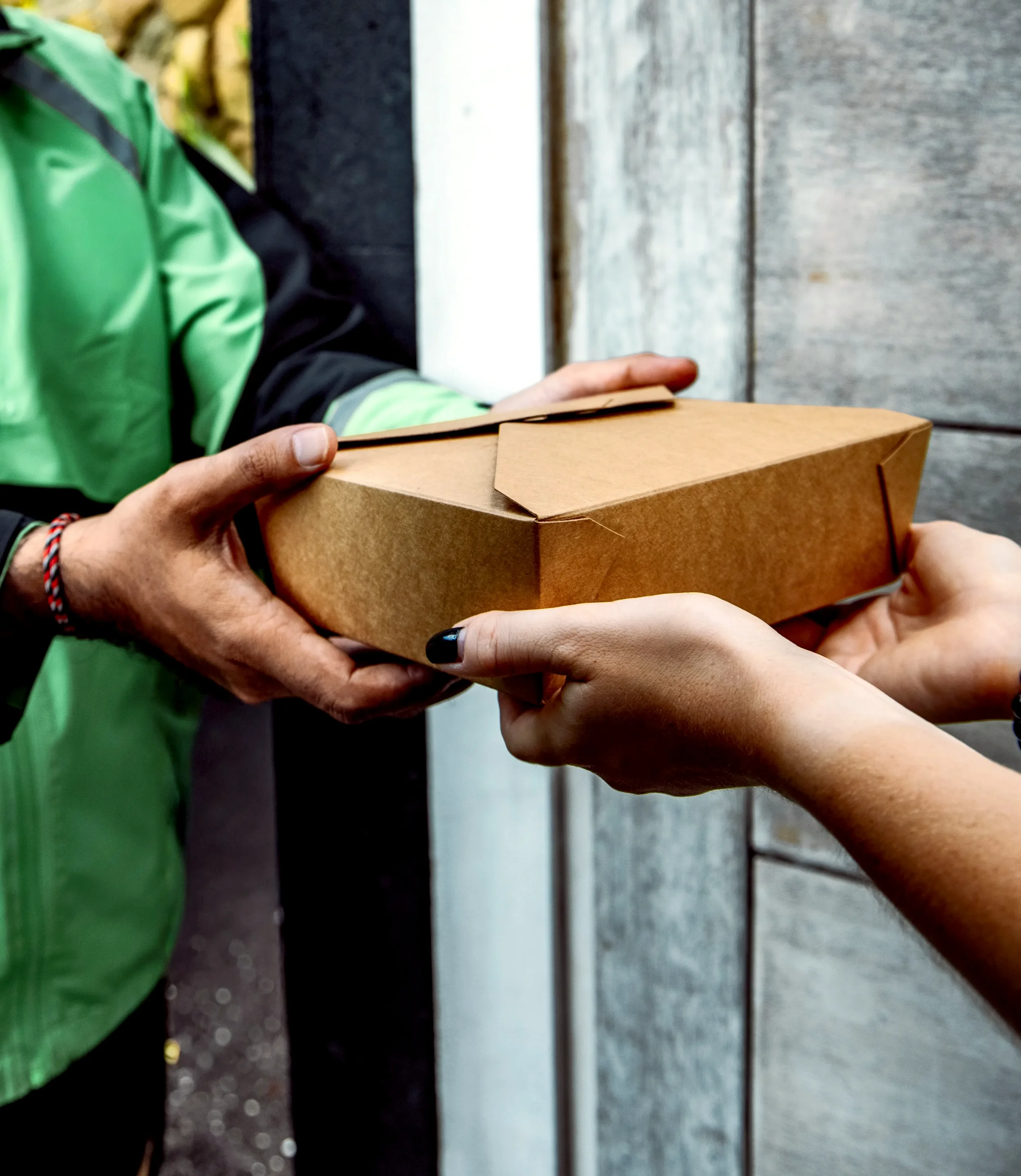 Close-up of hands delivering a boxed meal as part of the pastoral care for St. Thomas’ Church Whitemarsh.