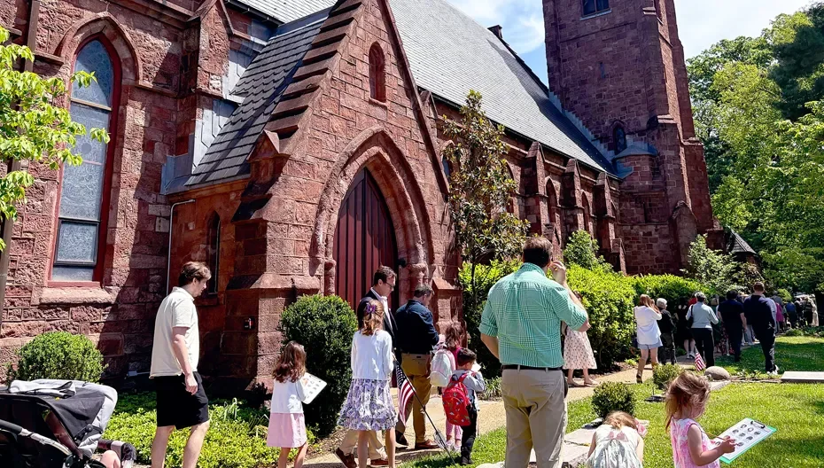 Congregants, including families with children, walk outside of the church into service at St. Thomas’ Church Whitemarsh.