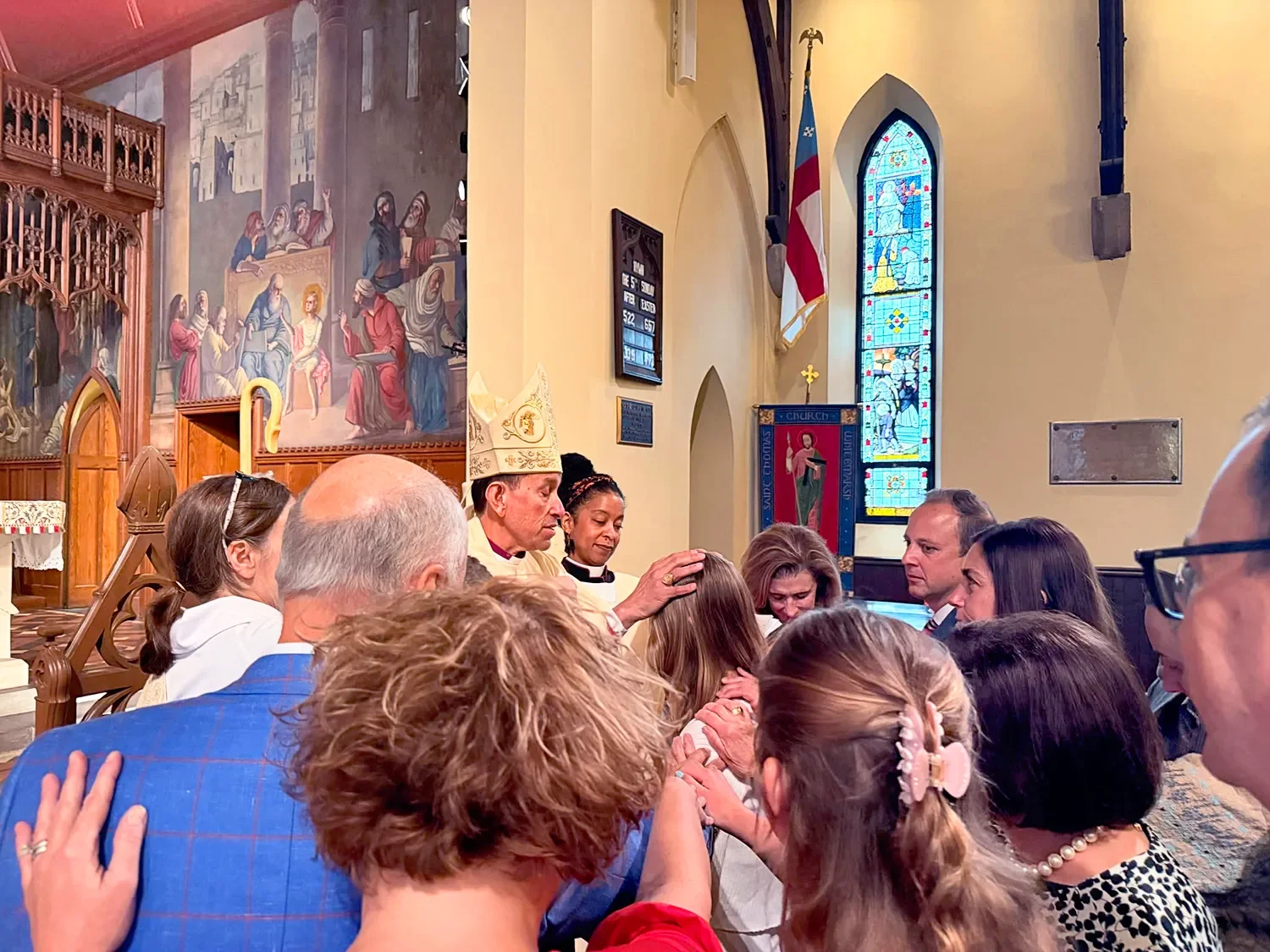 A bishop places a hand on a young person’s head during confirmation at St. Thomas’ Church Whitemarsh.