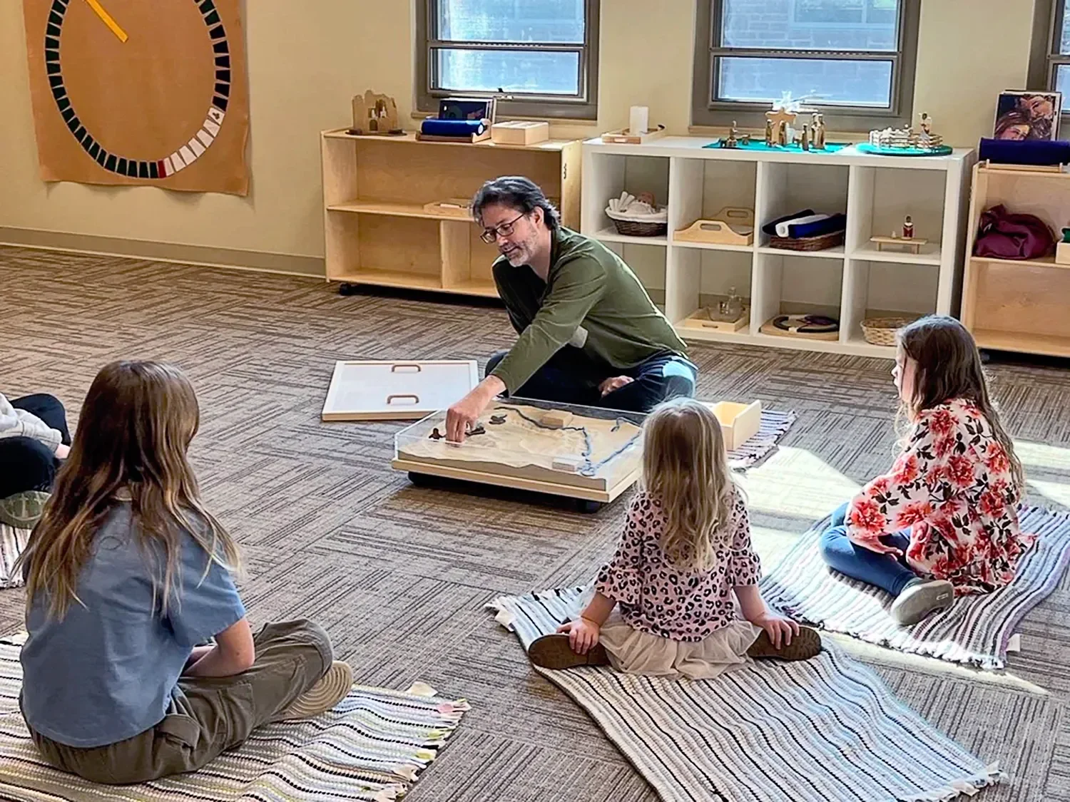 Children sitting on mats in a semi-circle around an instructor learning about Godly Play® at St. Thomas’ Church Whitemarsh.