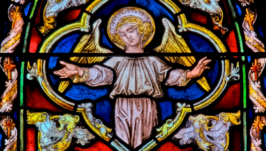 Stained‑glass depiction of an angel with golden wings and a halo inside the main church at St. Thomas’ Church Whitemarsh.