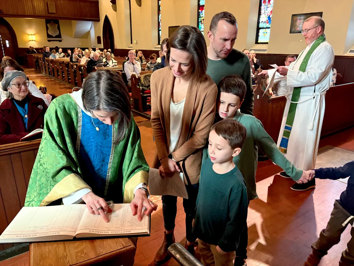 Mother Amy adding a new family to the baptized members log during a service at St. Thomas’ Church Whitemarsh.
