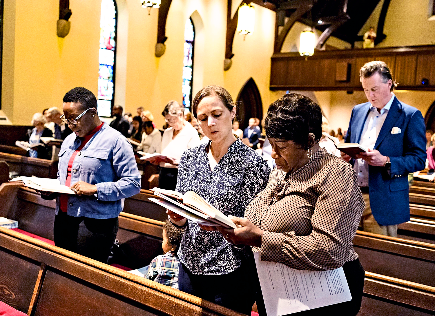 Parish singing from hymnal during a service at St. Thomas’ Church Whitemarsh.