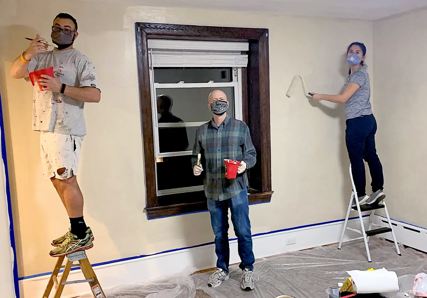 Three people wearing masks and painting a room as outreach from St. Thomas Church Whitemarsh.