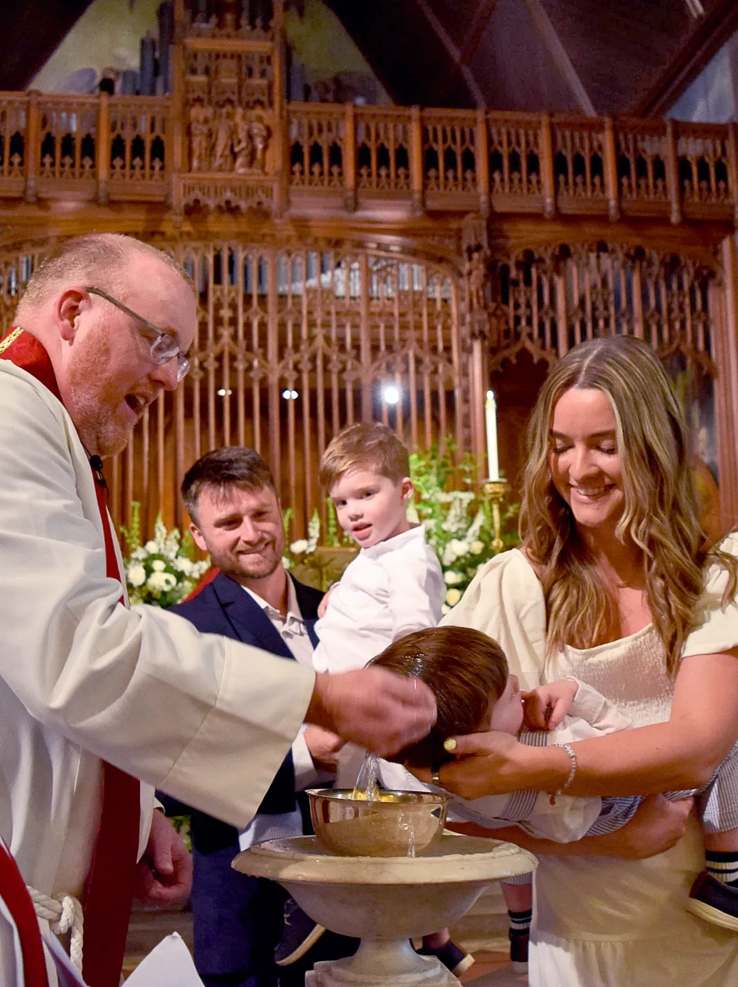 Father Dave baptizing a young child at St. Thomas’ Church Whitemarsh.
