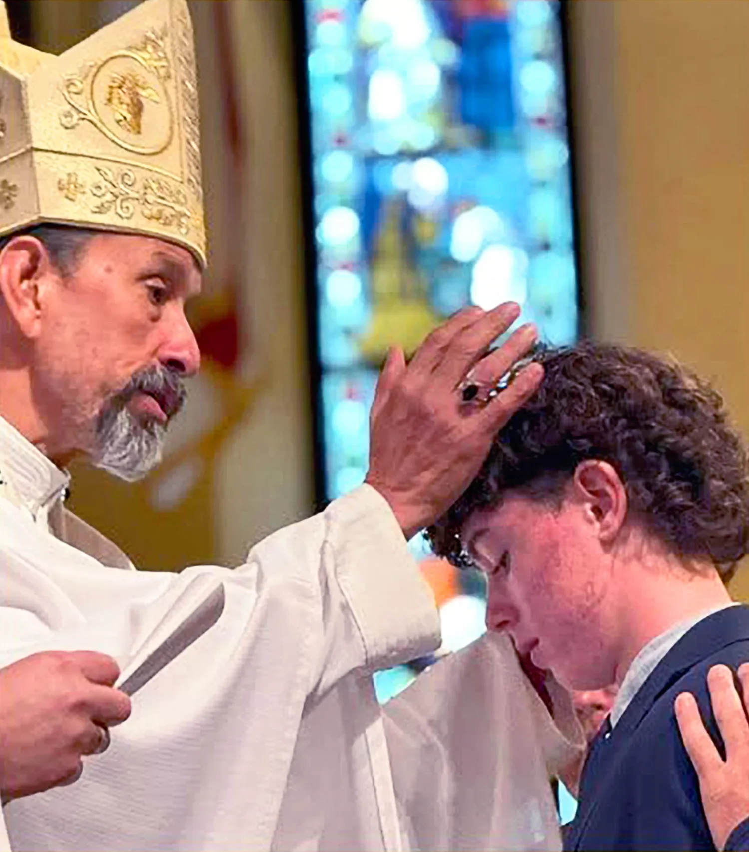 A bishop places a hand on a young person’s head during confirmation at St. Thomas’ Church Whitemarsh.