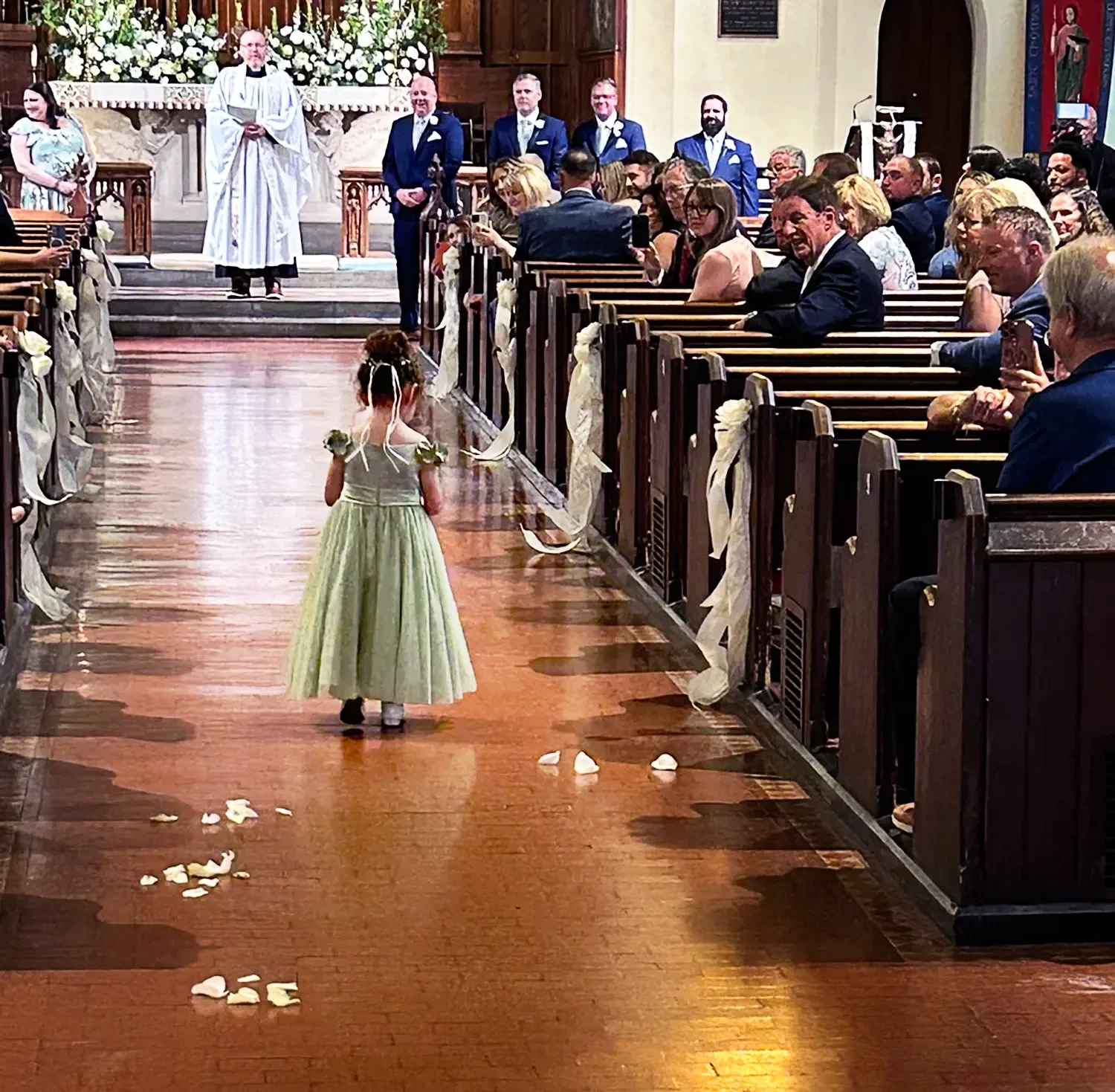 Flower girl walks down the aisle in the main church at St. Thomas’ Church Whitemarsh.