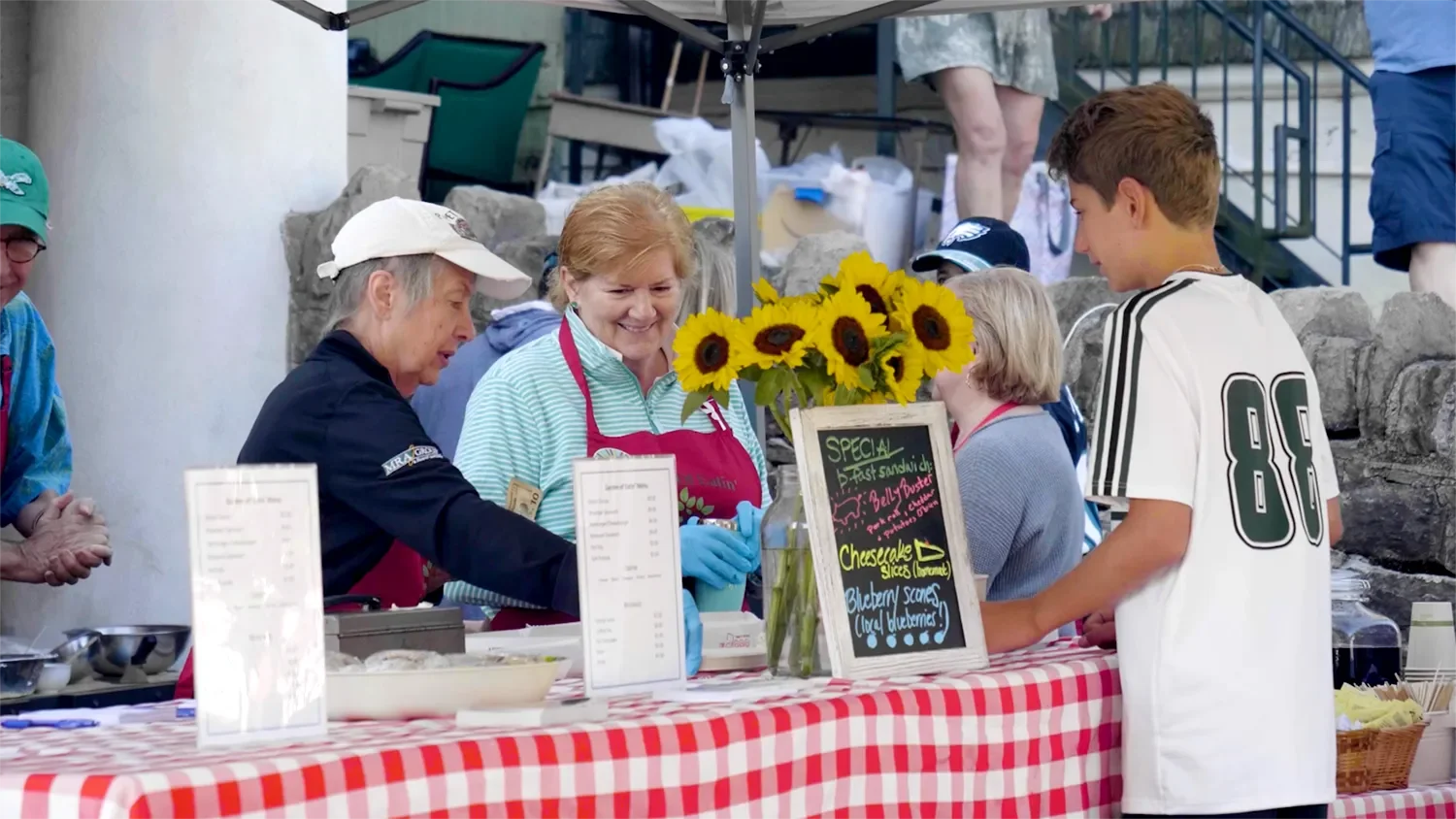 A young man buying food for sale outside at The Barn at St. Thomas’ Church Whitemarsh.