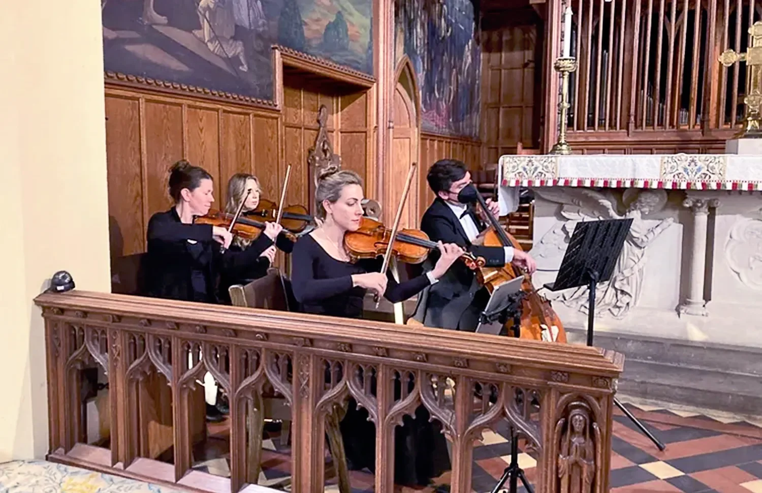 A string quartet plays during a wedding in the main church at St. Thomas’ Church Whitemarsh.