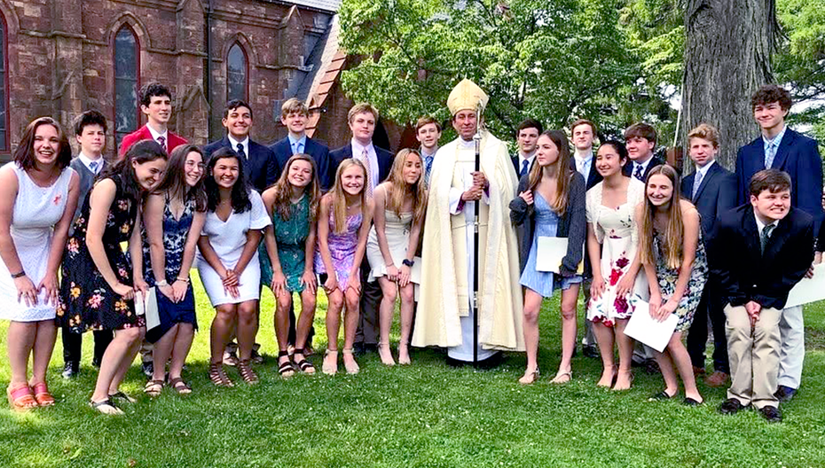 Bishop standing outside with a group of young adults at St. Thomas’ Church Whitemarsh.