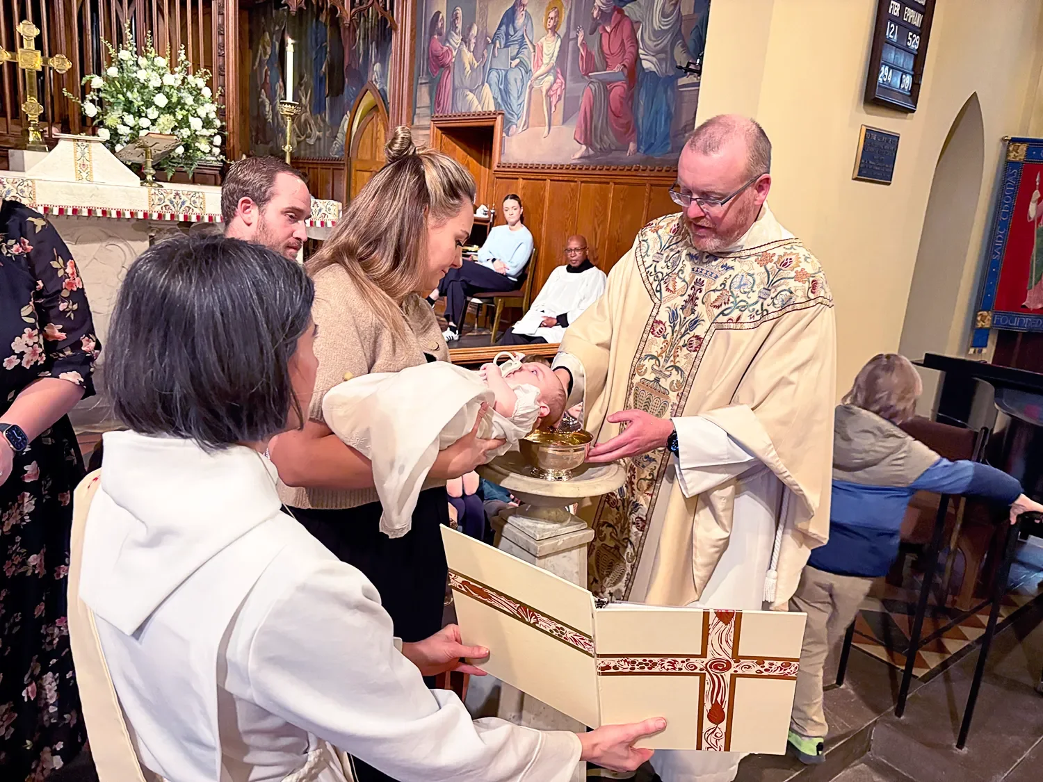 Father Dave baptizing a baby at St. Thomas’ Church Whitemarsh.