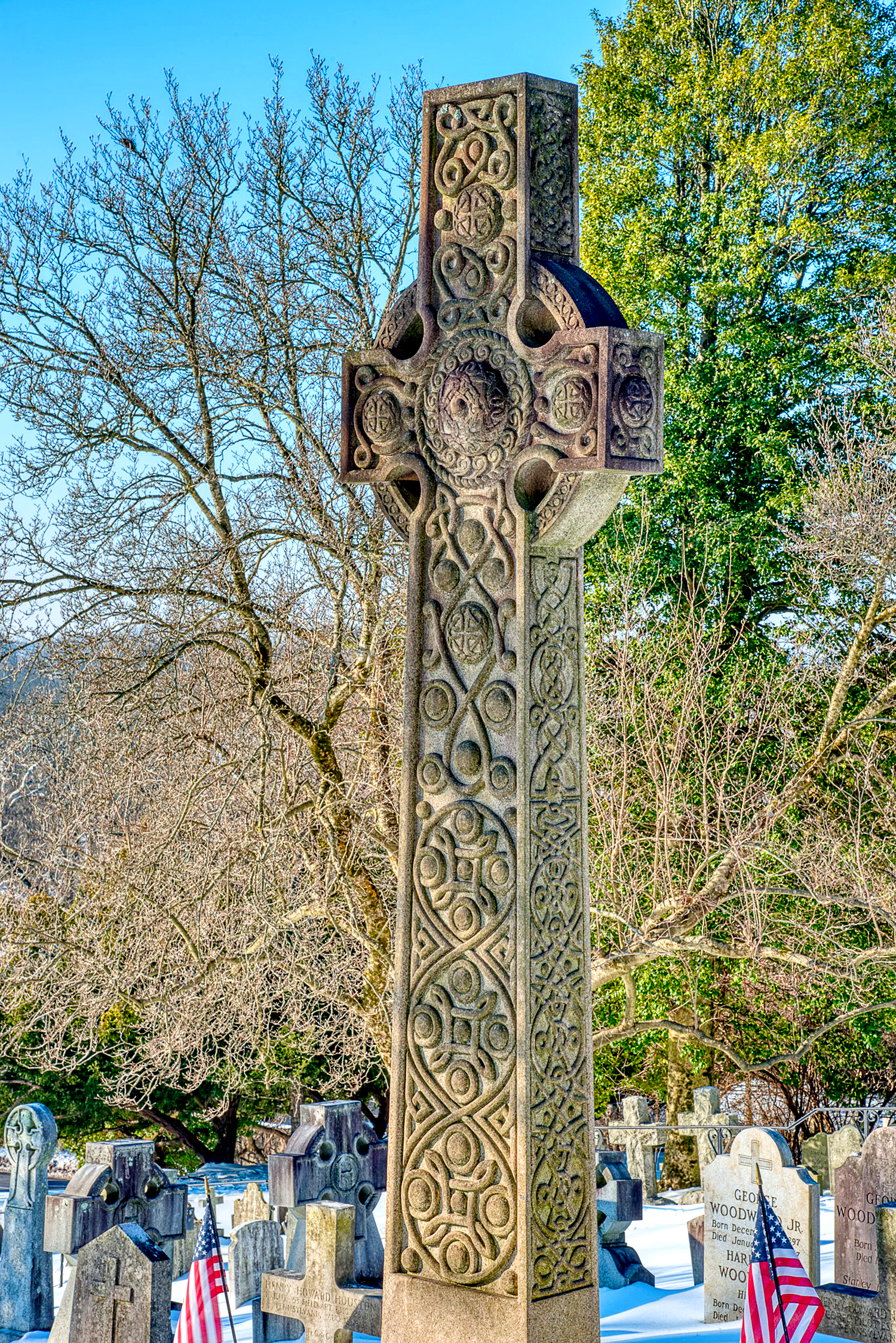 Ornate carved cross headstone during winter in the historic cemetery at St. Thomas’ Church Whitemarsh.