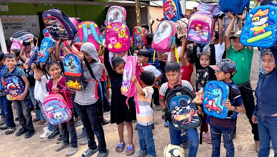 A group of children holding new backpacks as part of the Little Roses program in Honduras through St. Thomas’ Church Whitemarsh.