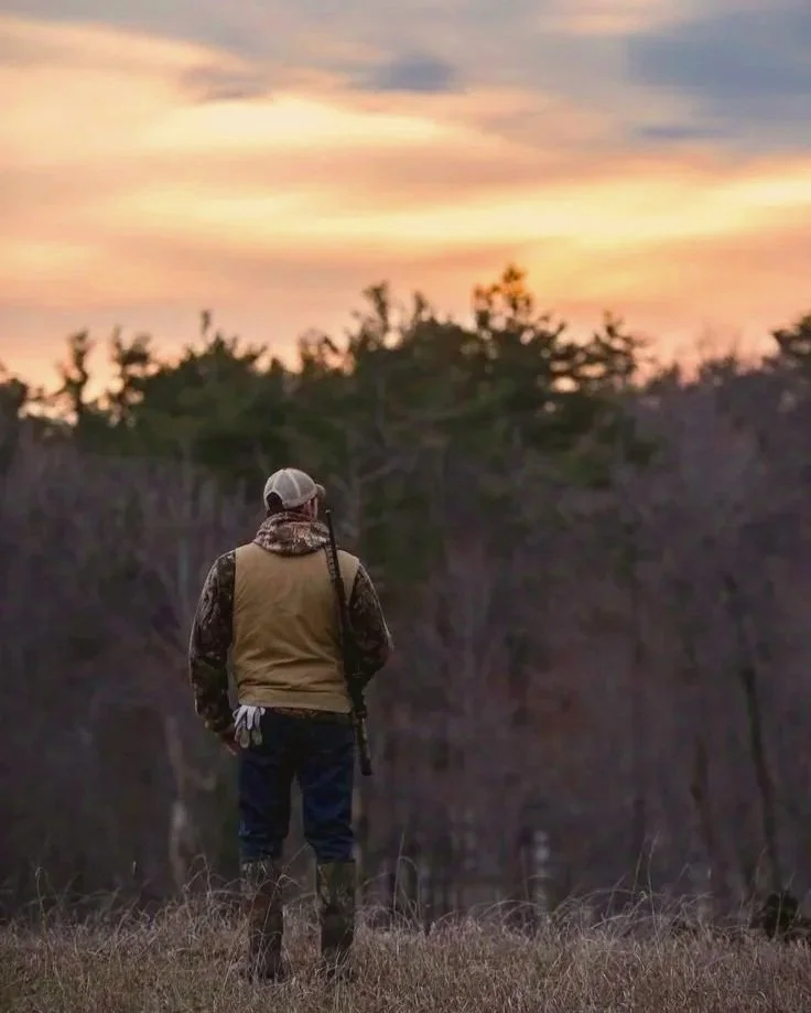 Experienced hunting guide scouting a field during a guided deer hunt.