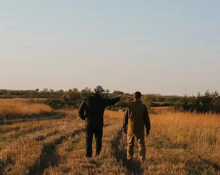 Hunting guide discussing strategy and hunt planning with a hunter in the field before a guided hunt.