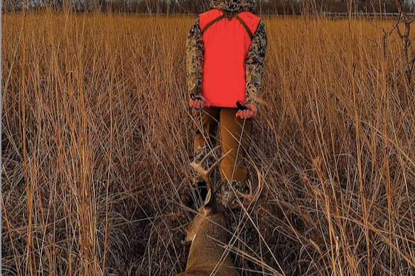 Hunter recovering a harvested whitetail deer during a guided hunting trip