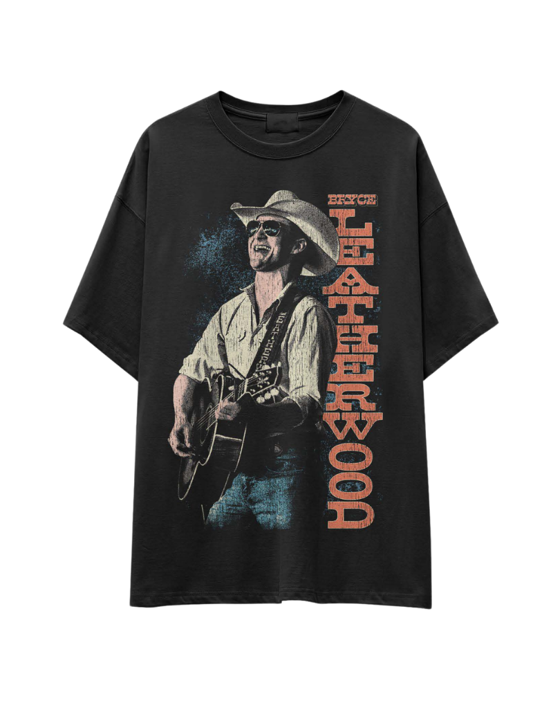 Black T-shirt featuring a graphic of a man in a cowboy hat and sunglasses playing a guitar, with the text 'Booth Boy' and 'Bruce' written vertically.