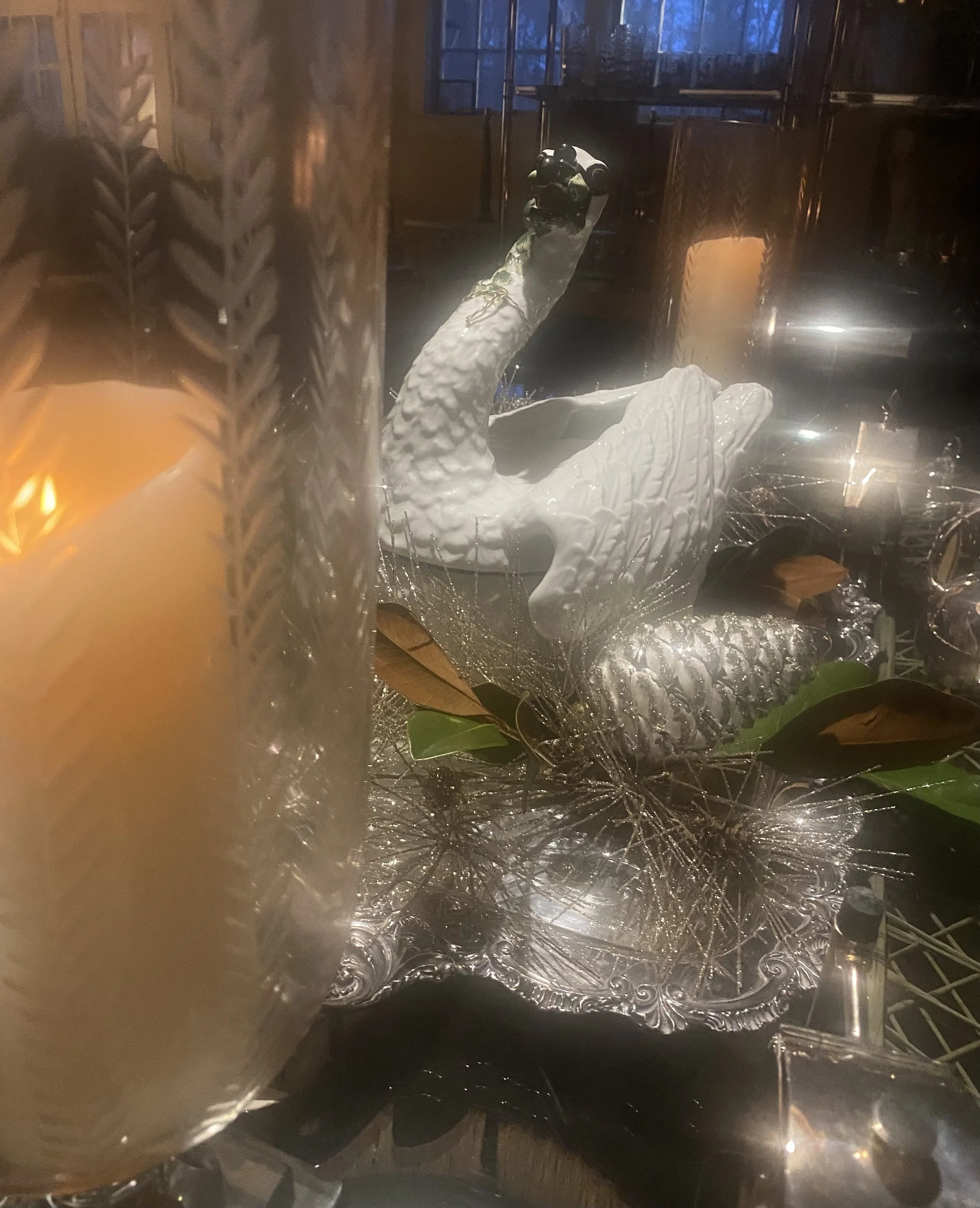 Close-up of a shiny, ornate silver tray with a decorative pattern, viewed through a translucent surface that distorts the image.
